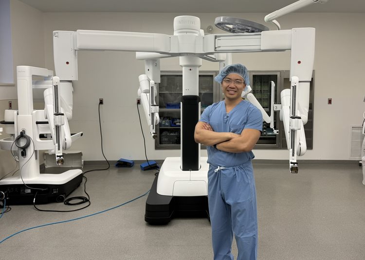 Dr. David Ma stands with the new robotic surgical tool